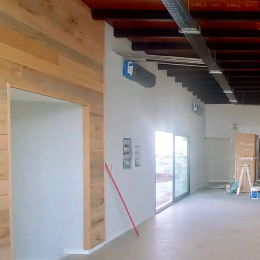 Local comercial Arias Hnos. terminado, con cielorraso, iluminación lineal y revestimiento de madera