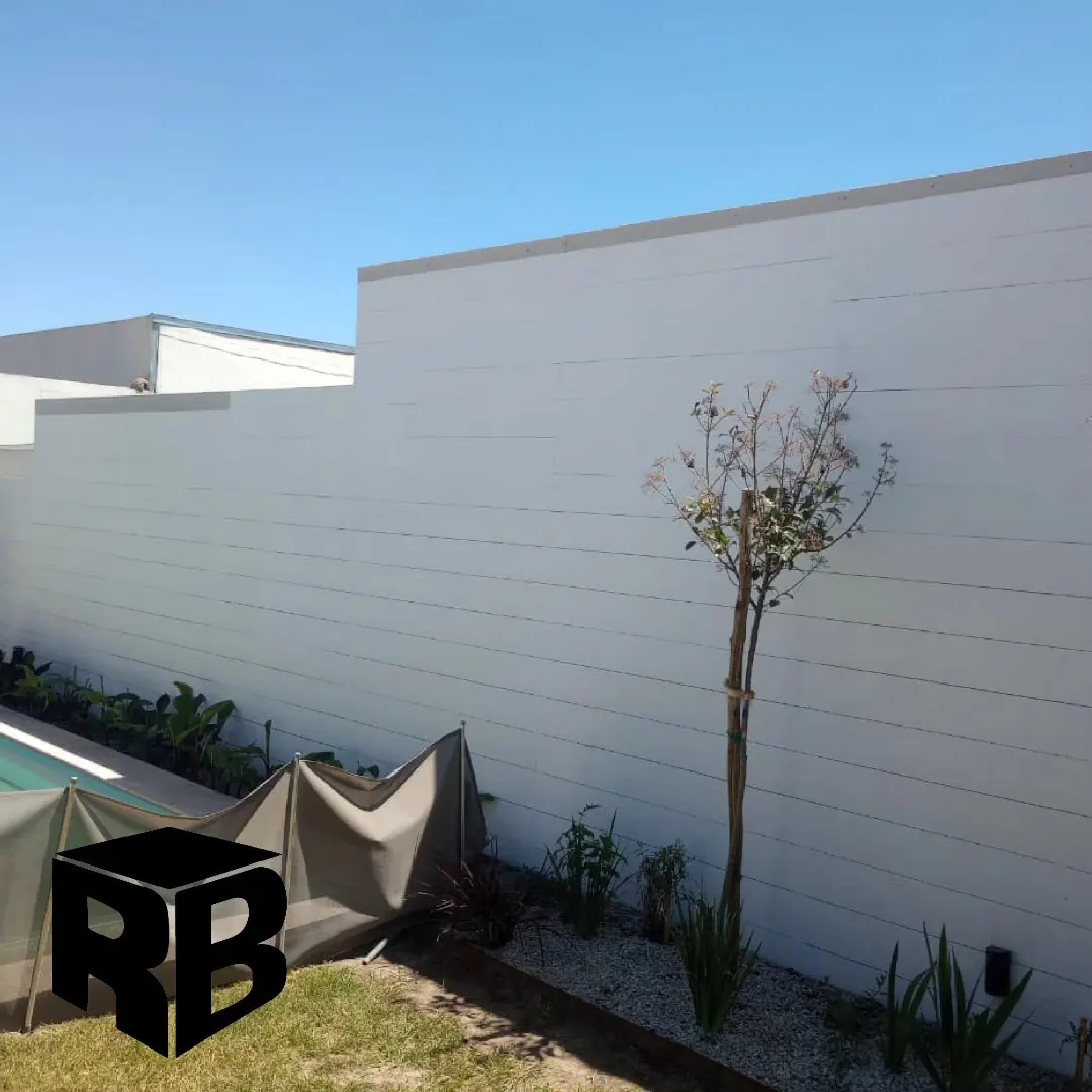 Muro exterior revestido con paneles siding, junto a una pileta